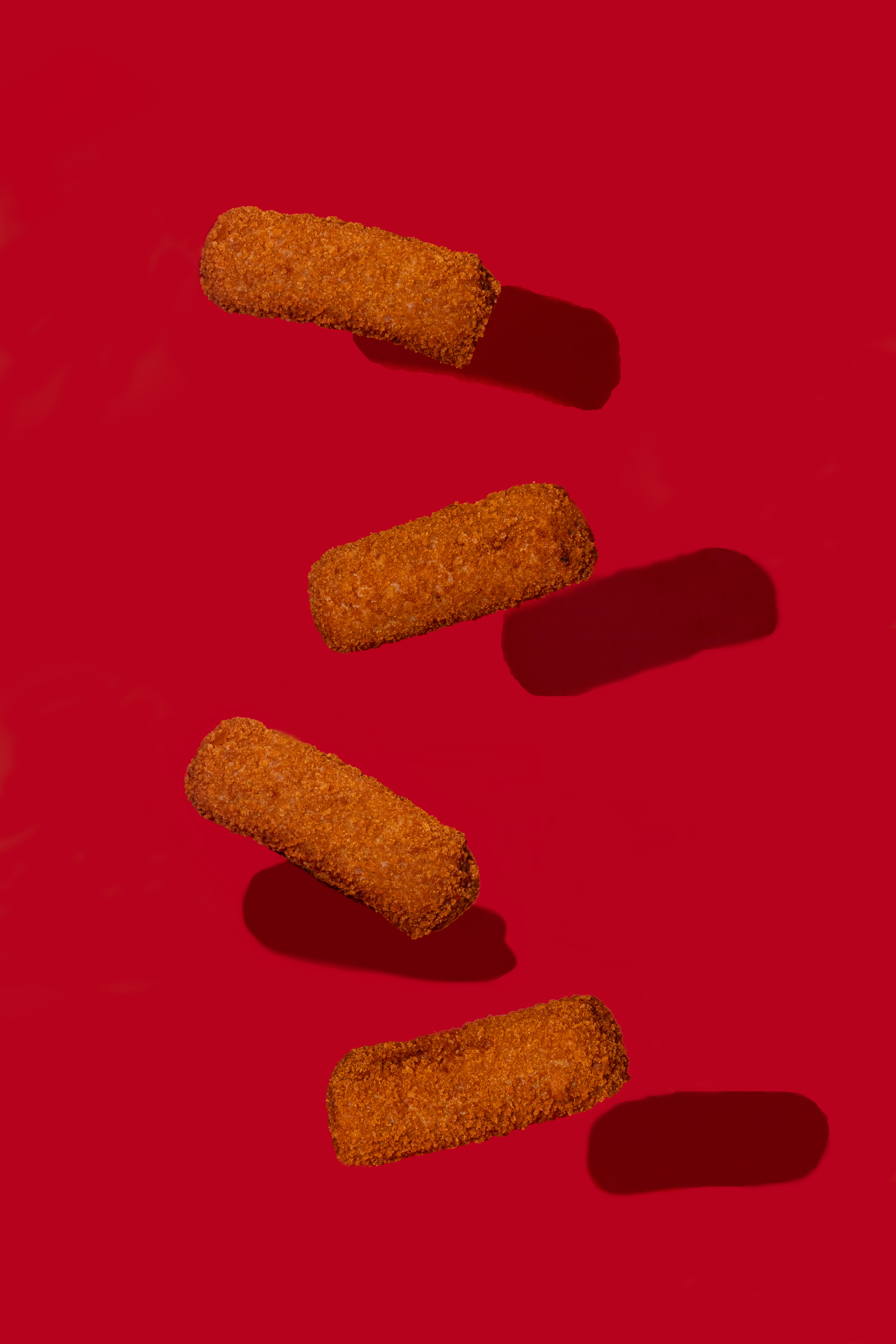 Four golden croquetas on Vicky Bakery red, fresh from the fryer.